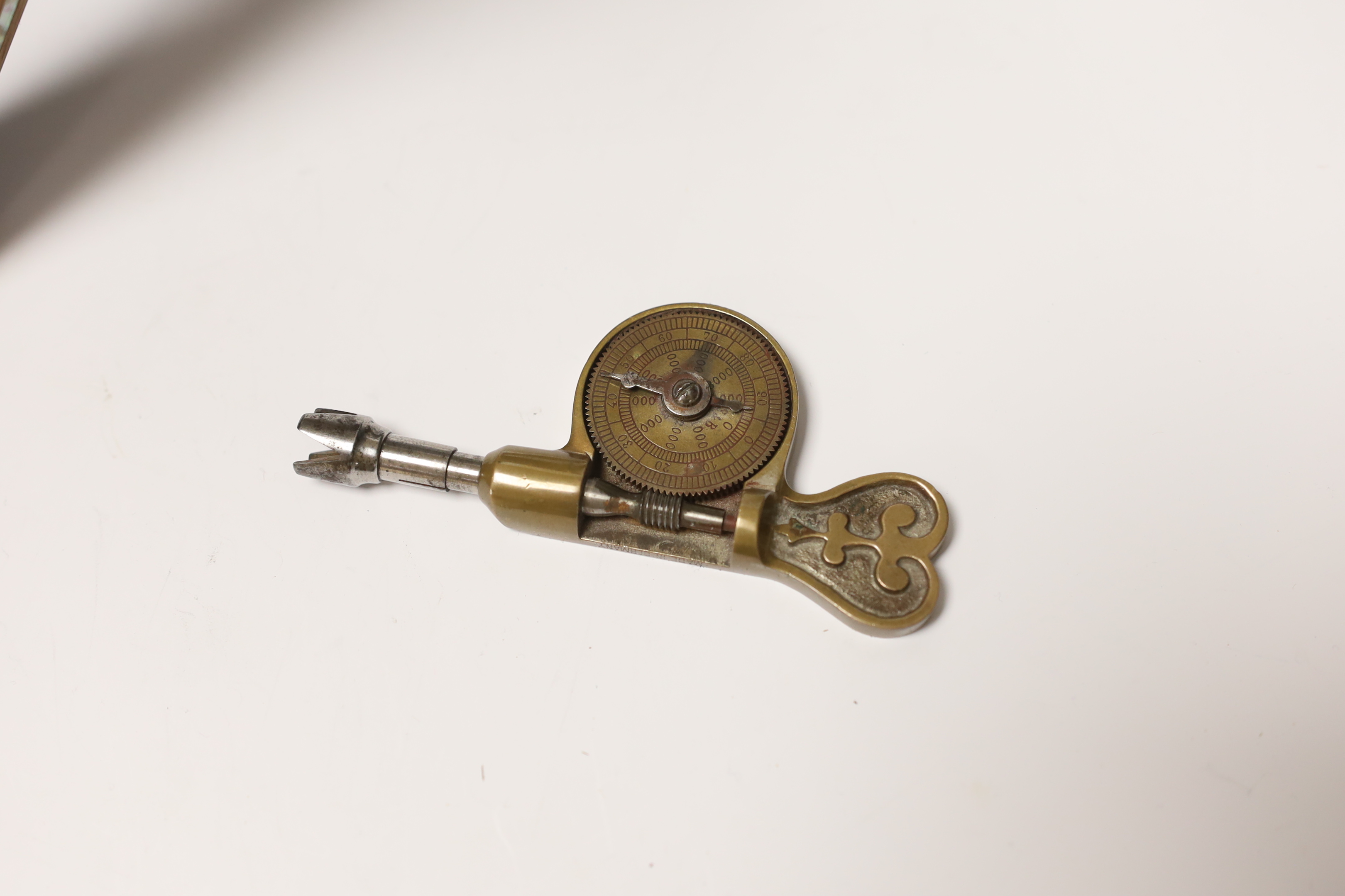 A pair of early 20th century brass garnitures, a German brass tachometer and a mother of pearl inlaid Quran stand, tallest 25cm